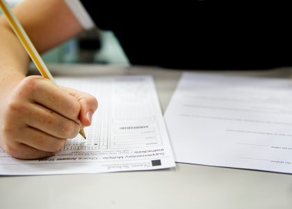 Person füllt Abschlussprüfung aus